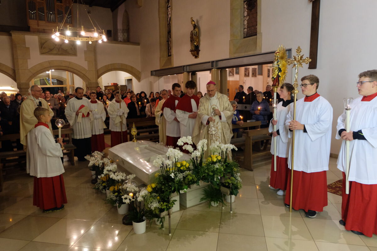 Gläubge und liturgischer Dienst beten am Grab der hl. Anna Schäffer für die Anliegen von Kirche und Welt